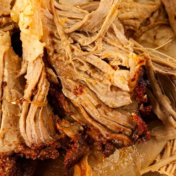 Close-up of tender, juicy shredded pork with crispy, caramelized edges.