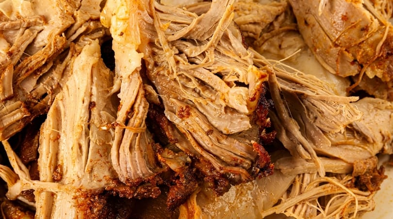 Close-up of tender, juicy shredded pork with crispy, caramelized edges.